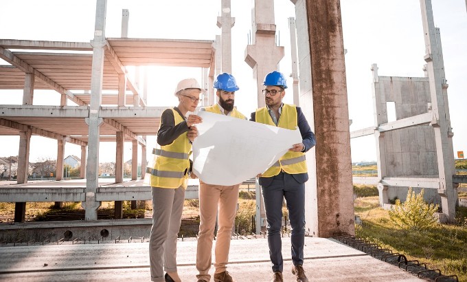 three professionals at construction site studying a project to introduce paragraph about Engineering and Architectural services